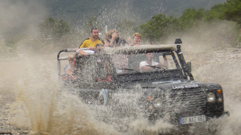 Antalya'nın köprülü kanyon köyünde jeep turu. suyun içine girmiş jeep Ormanın içinde çamurlu ve tozlu.