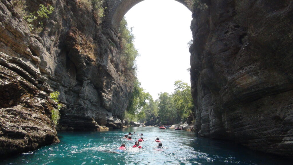 Roma köprüsü. Köprünün altında yüzen insanlar. Rafting start noktasına gidiyorlar.